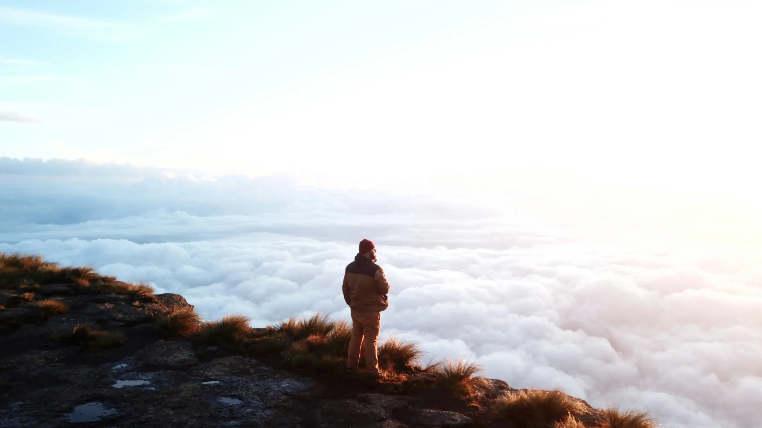 Hiker standing on top of a mountain in the Drakensberg - © Unsplash